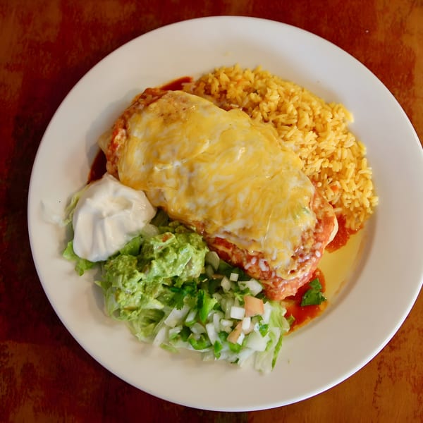 Delicious cheesy Mexican entree served with yellow rice, sour cream, guacamole, and fresh salad.